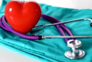 A set of scrubs, a stethoscope, and a heart on a table at a concierge medicine practice